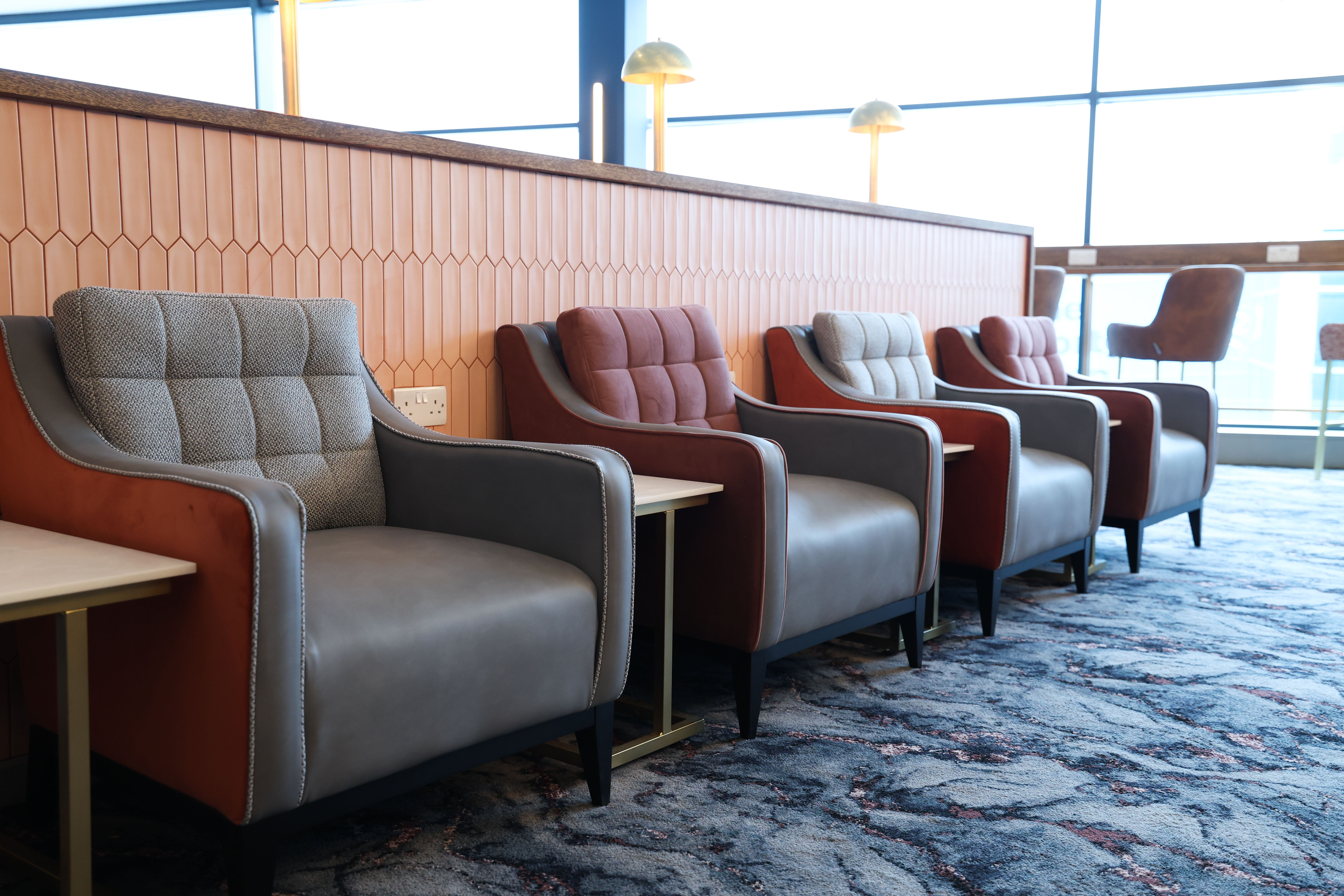 Row of comfortable armchairs in a bright seating area at the Belfast Aspire Lounge.