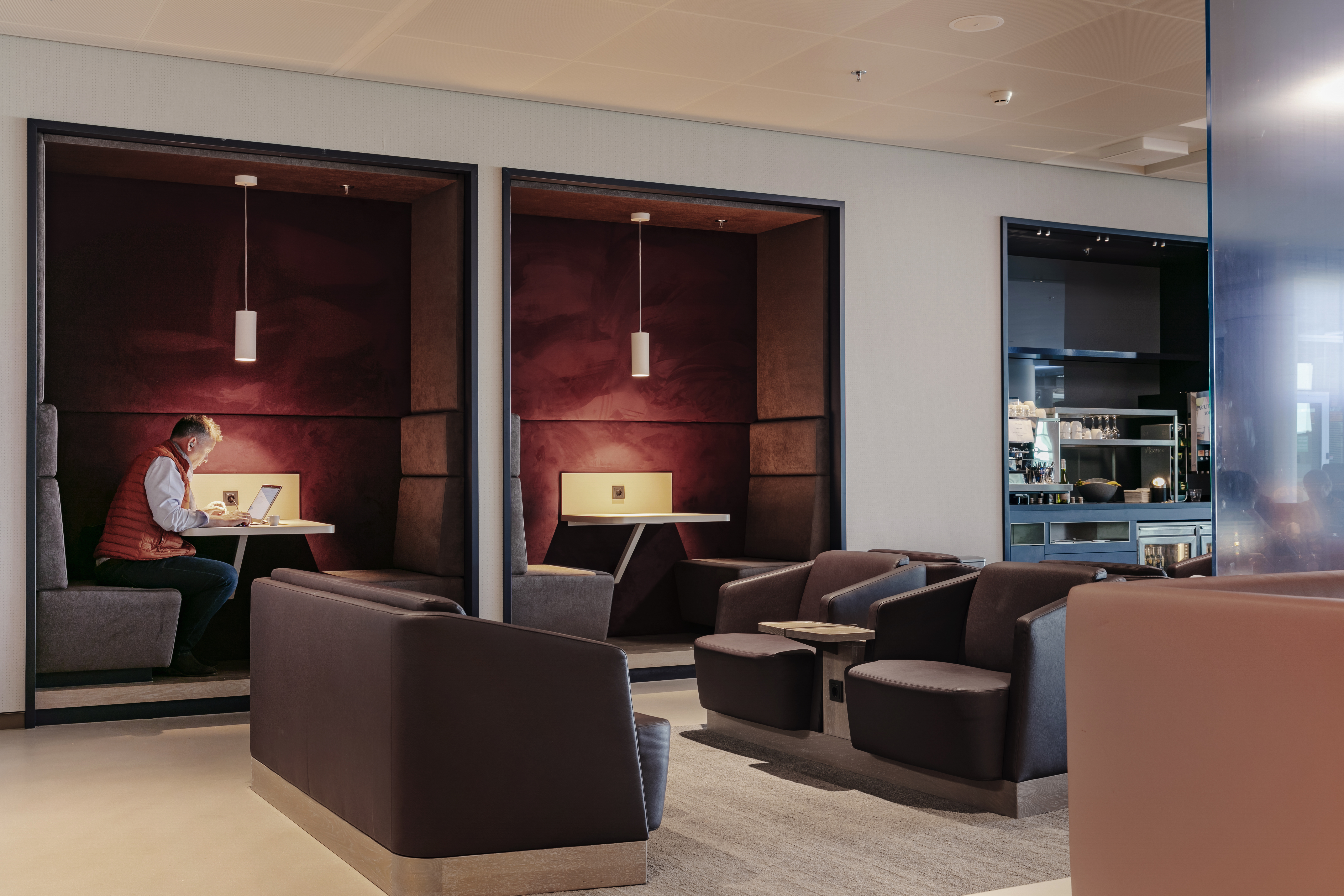 Private seating booth with comfortable seats and charging point at Amsterdam Gate 27 Aspire Lounge.
