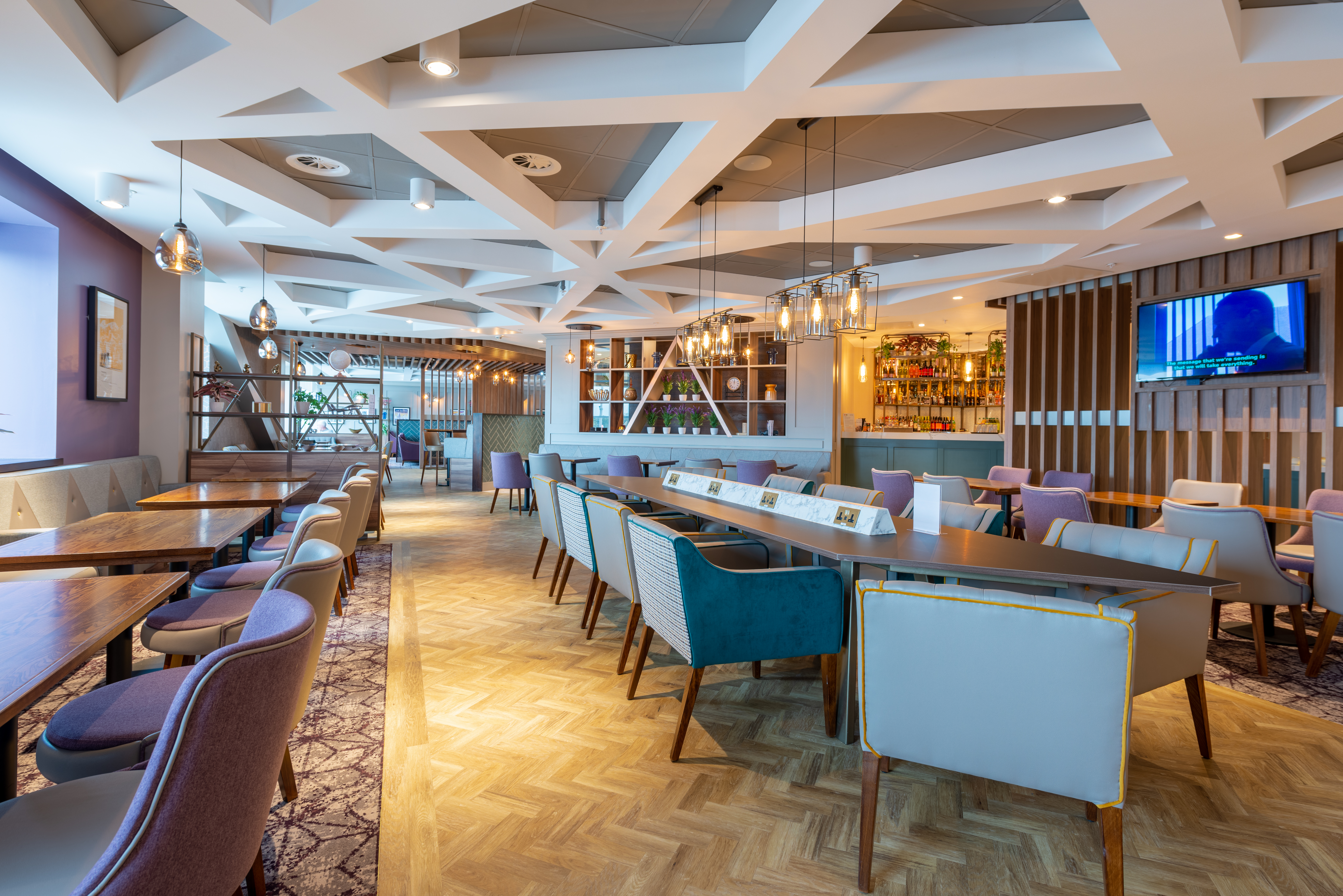 Chairs and tables with a charging point at Edinburgh Gate 16 Aspire Lounge