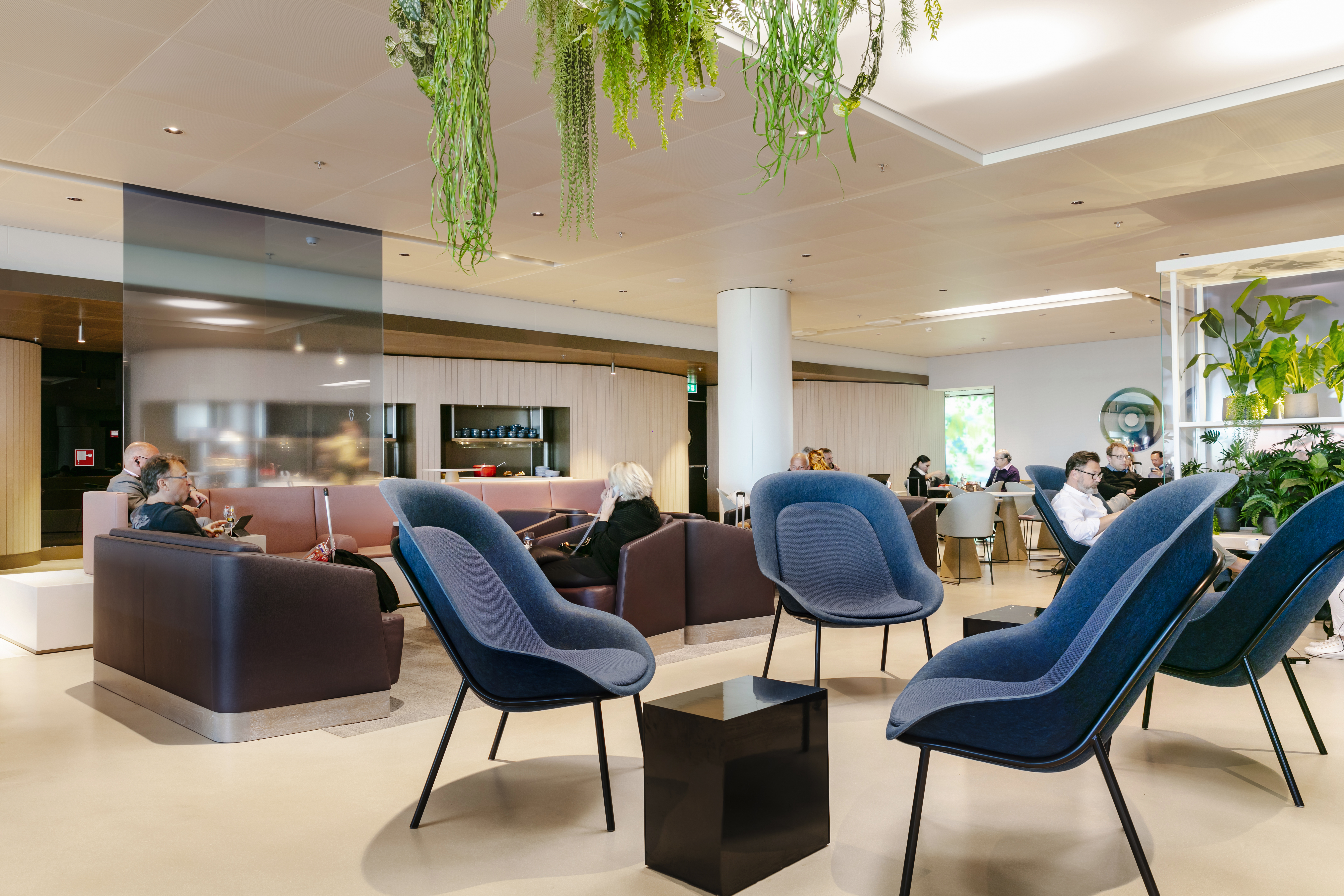 Blue lounge chairs to relax in Amsterdam Gate 26 Aspire Lounge.